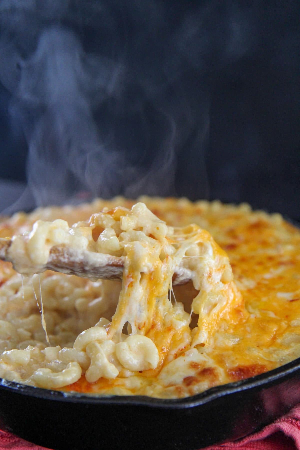 a spoonful of mac and cheese with steam in the background 