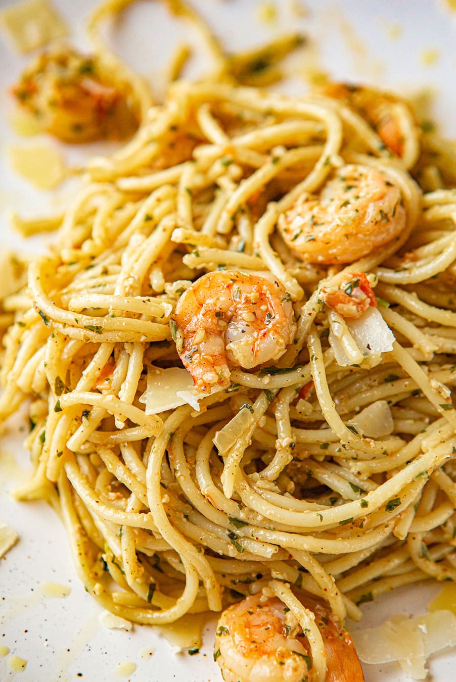 shrimp pesto spaghetti on a white plate up close. 