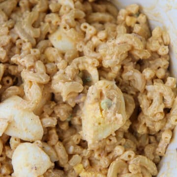 deviled egg pasta salad in a white bowl up close.