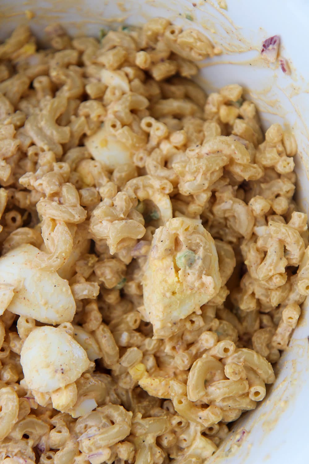 deviled egg pasta salad in a white bowl up close. 