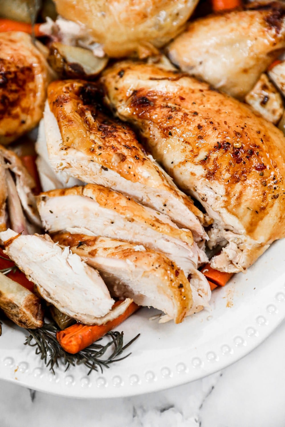 a whole chicken cut into pieces served on a white plate. 