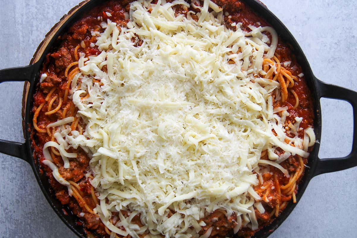 spaghetti, meat sauce, and shredded mozzarella cheese on top. 