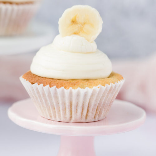 one banana cupcake on a small pink cake stand.