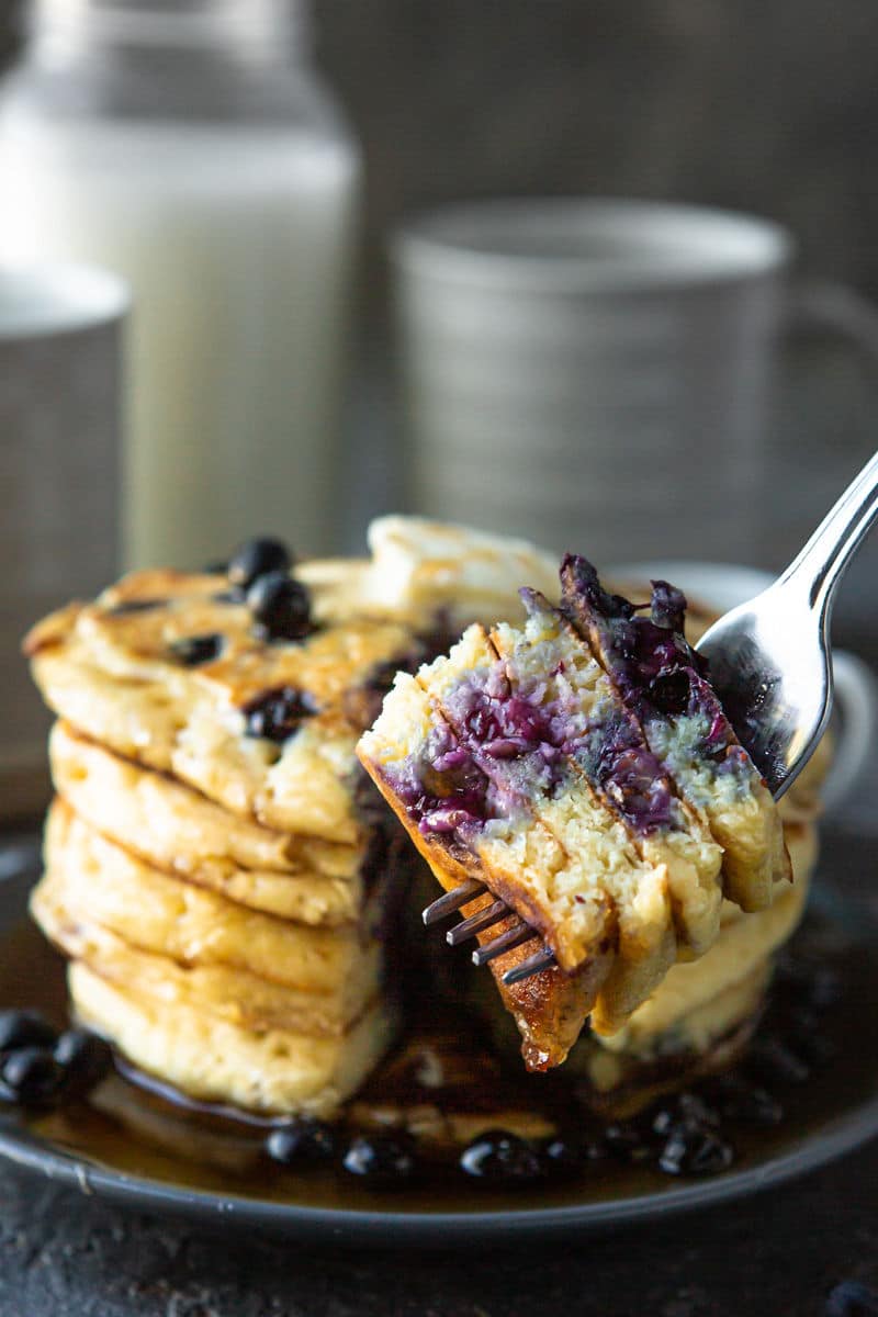 short stack on pancakes on a plate and a fork holding pancake pieces. 