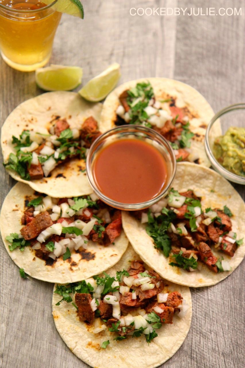 Homemade carne asada tacos served with chopped cilantro, onions, and lime