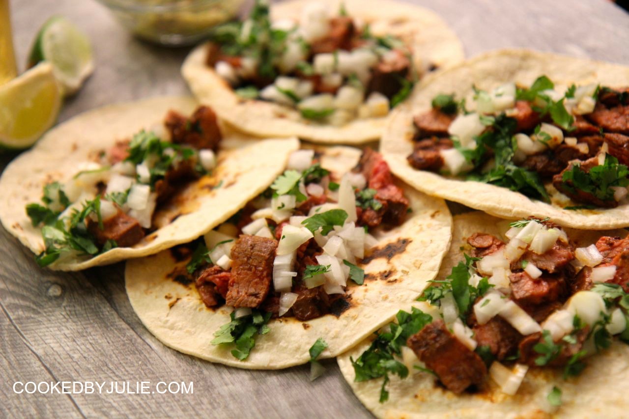 Carne asada tacos served on corn tortillas with onions and cilantro