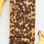chocolate peanut butter banana bread with two bananas on the side