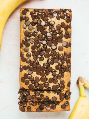 chocolate peanut butter banana bread with two bananas on the side