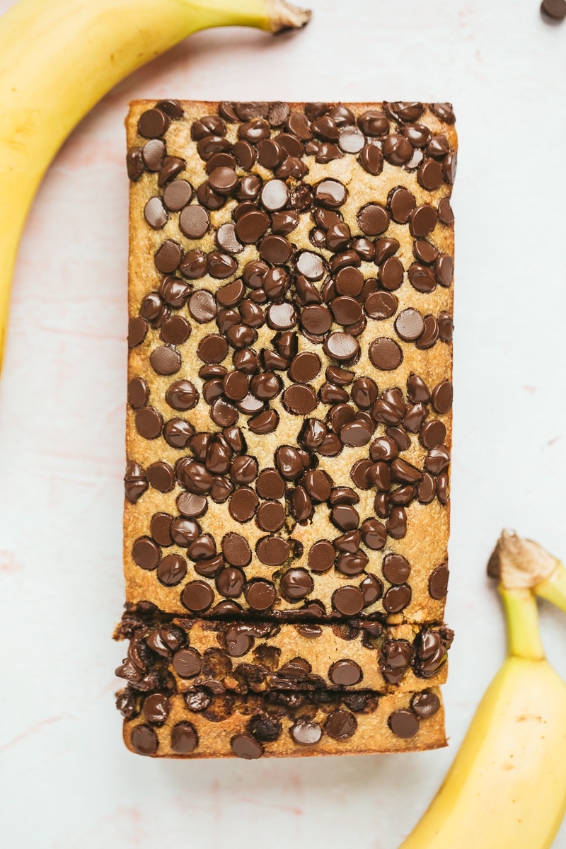chocolate peanut butter banana bread with two bananas on the side