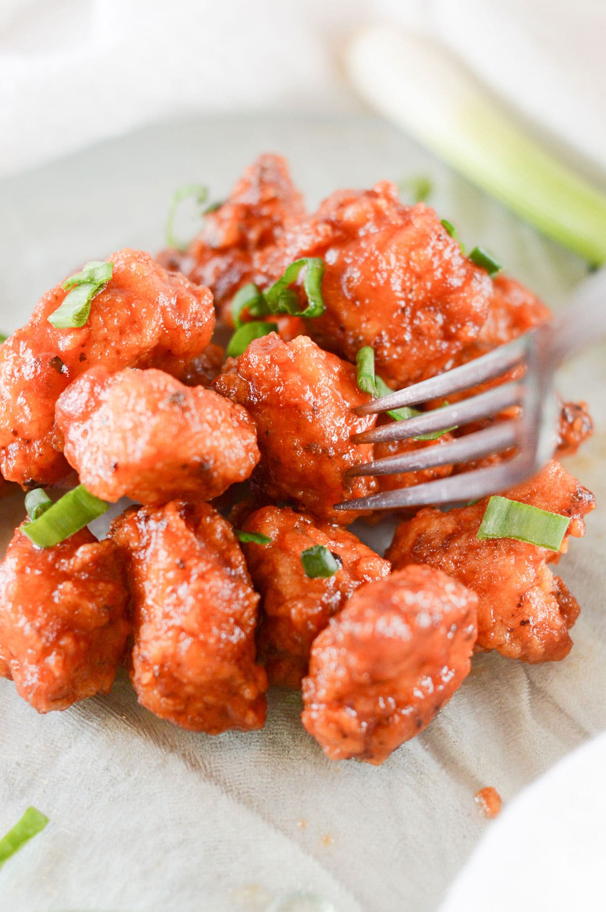 boneless wings coated in barbecue sauce with a fork 