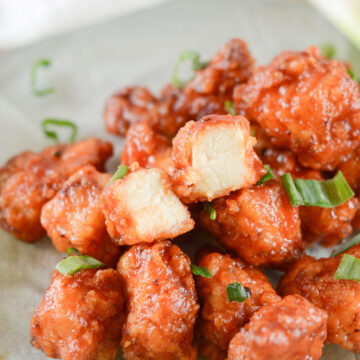 honey boneless bbq wings with scallions on a green plate