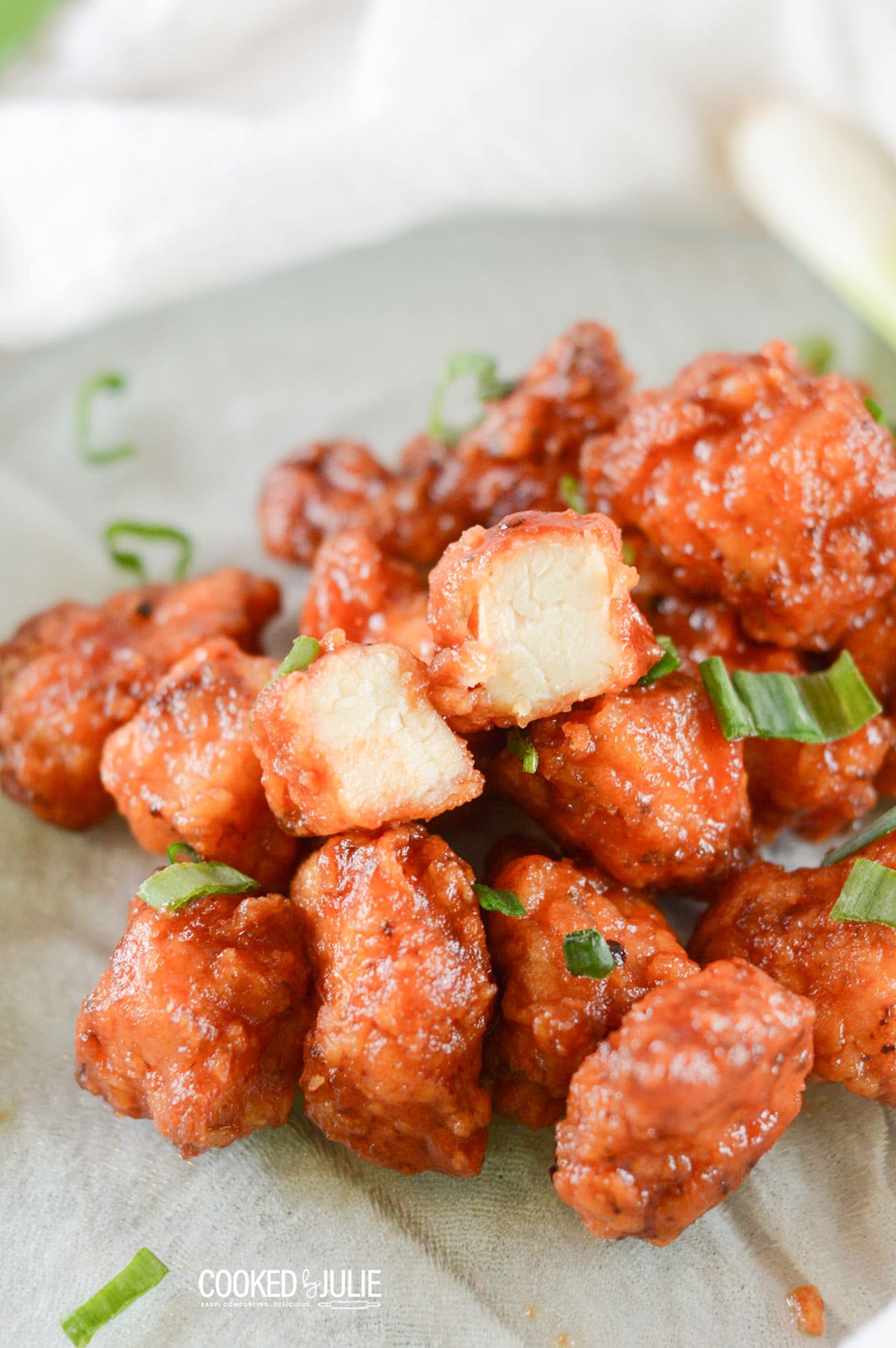 honey boneless bbq wings with scallions on a green plate