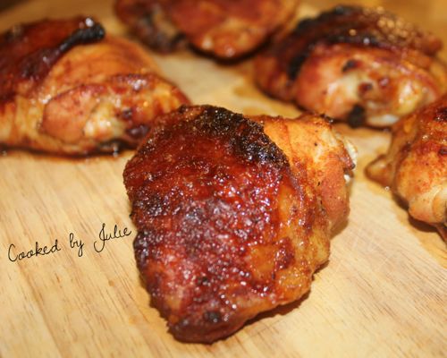 five spicy honey baked chicken thighs on a wooden board. One chicken thigh up close. 