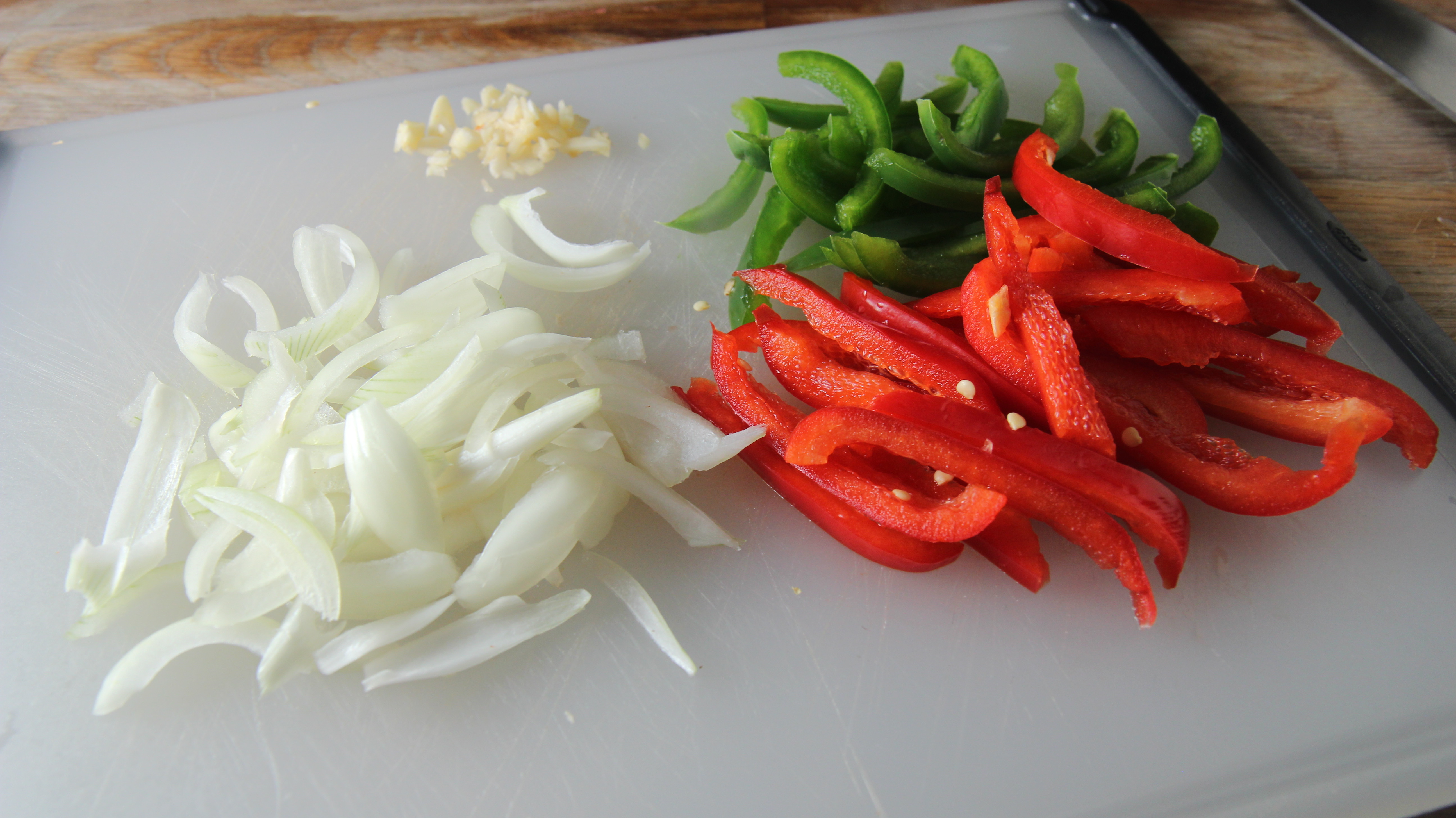 Chopped onions, garlic, and red and green peppers are the vegetables we need for our easy skillet cod dinner. 