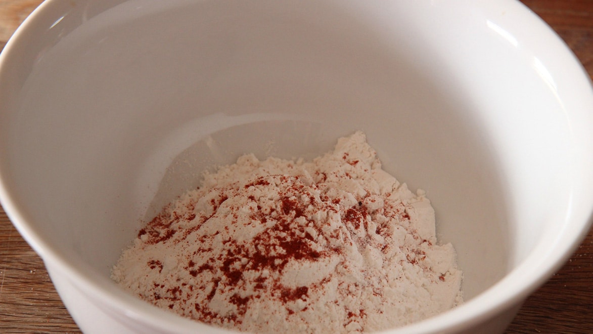 all-purpose flour, paprika, granulated garlic, oregano, salt, and pepper in a white bowl. 
