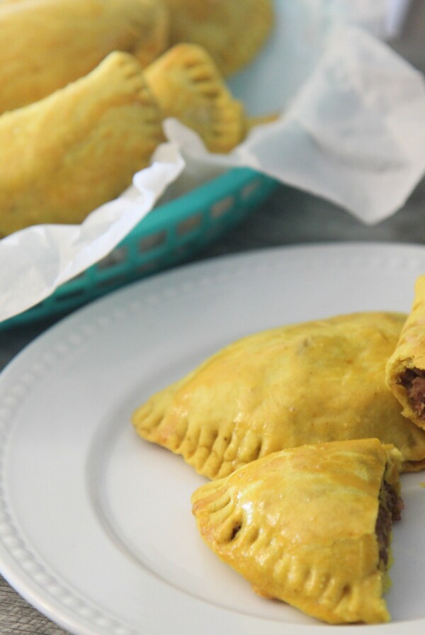 Jamaican beef patties in a basket and a white plate