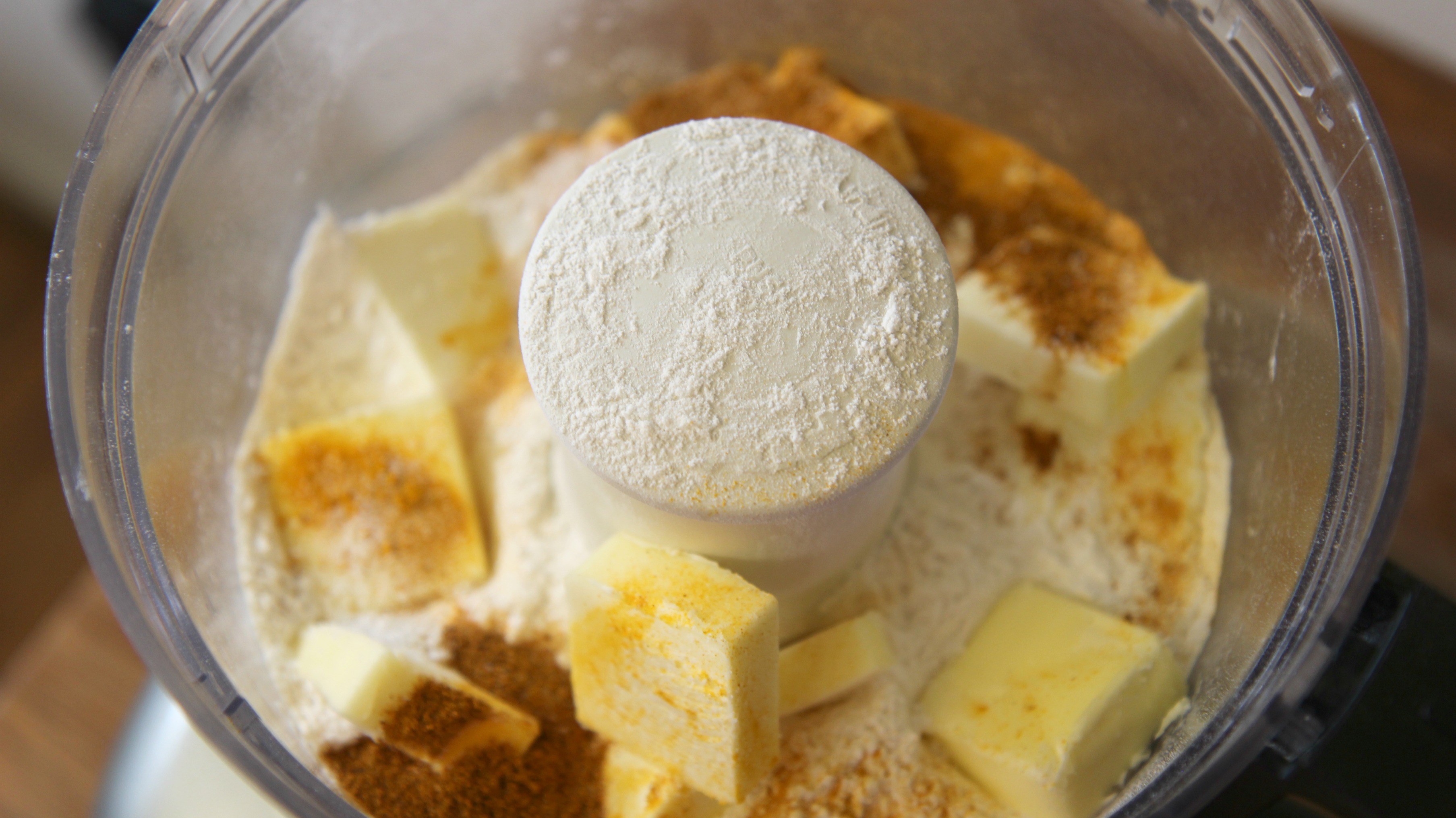 Close up shot of the wet and dry ingredients in a food processor.