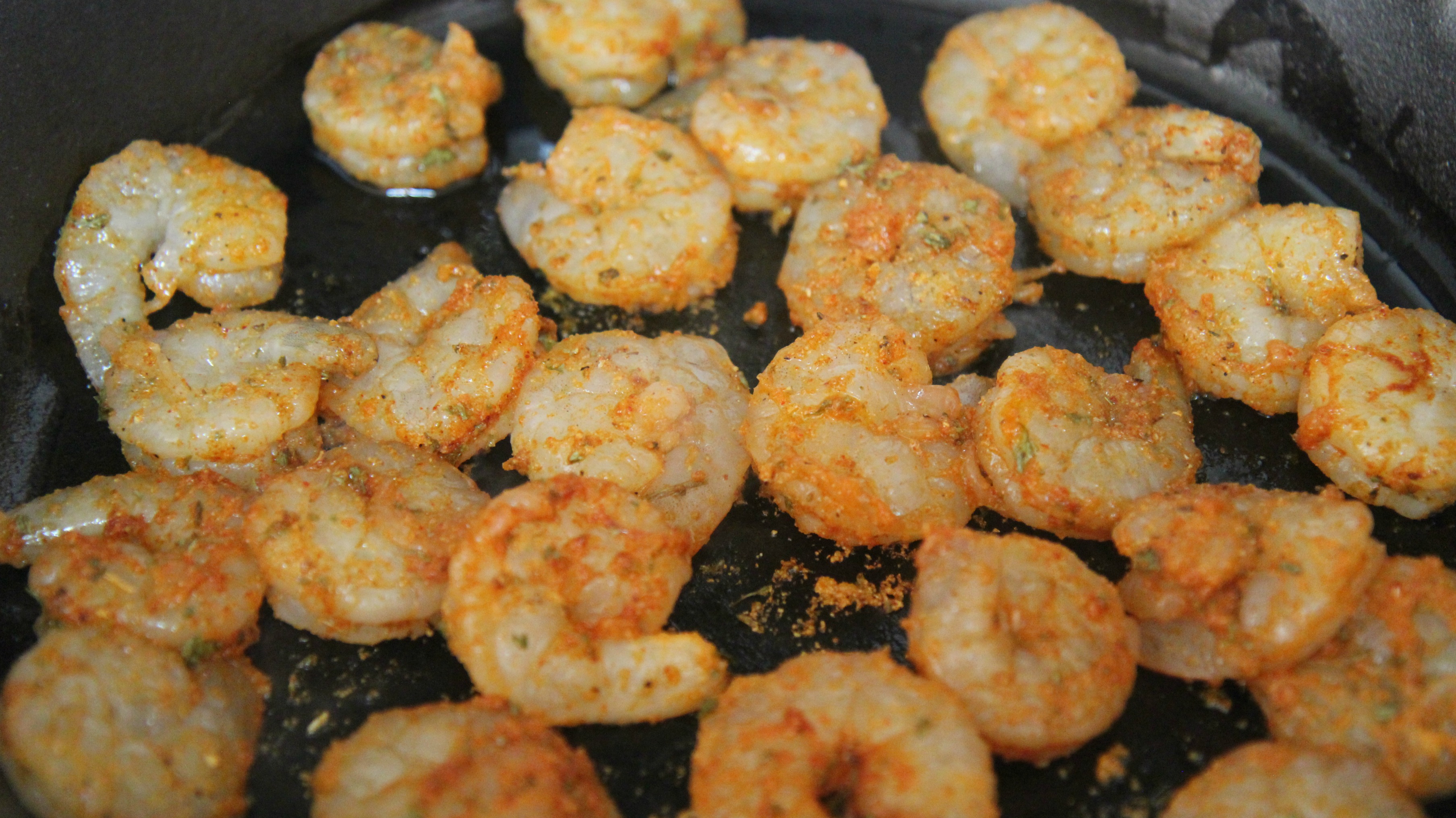 Cooking shrimp in a black iron skillet. 