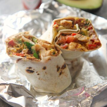 tex mex grilled chicken burrito on aluminum foil.