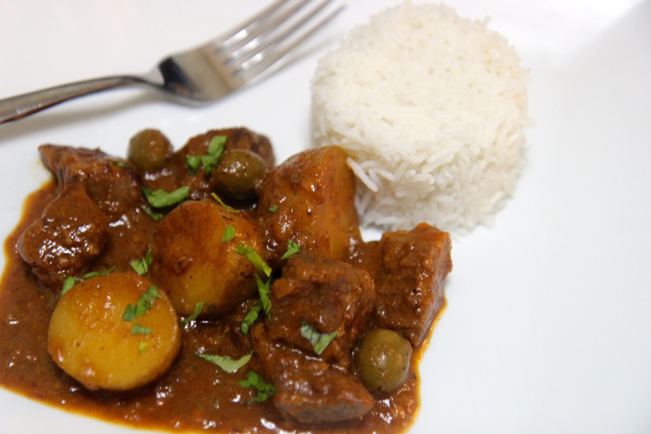 carne con papa with white rice and a fork on a white plate 