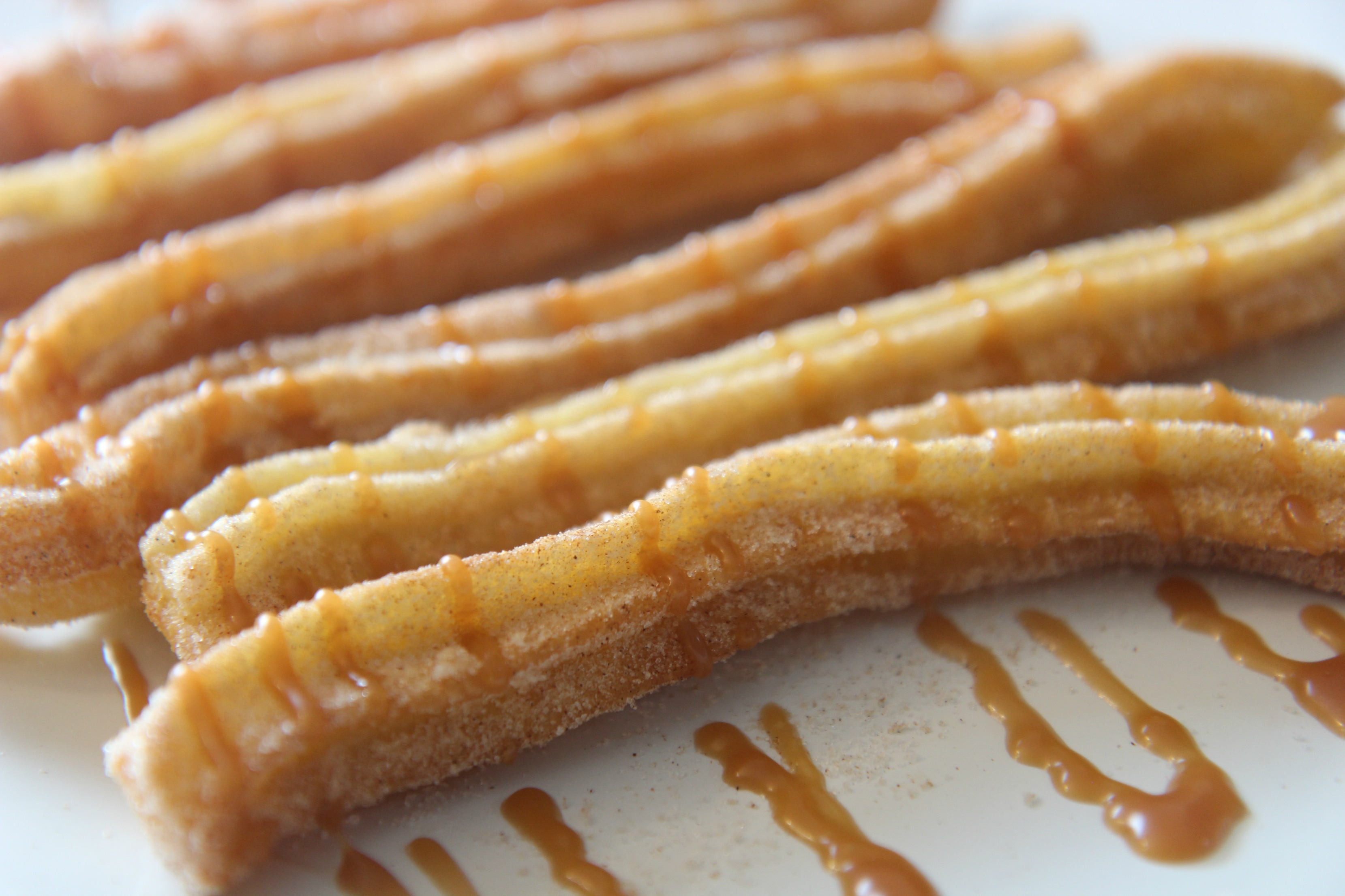 fried dough with cinnamon sugar and caramel on a white plate 