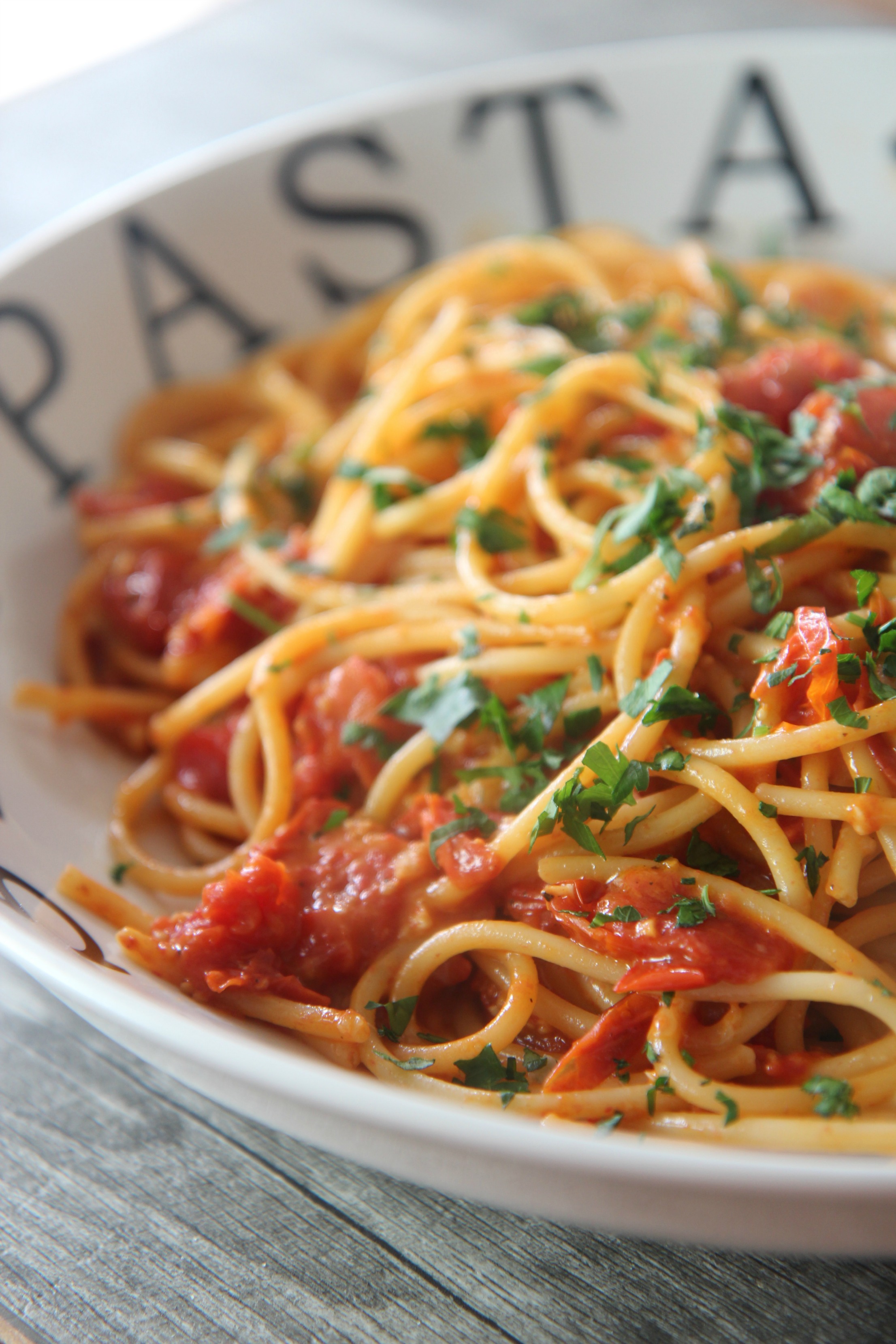 Tender angel hair pasta coasted in freshly roasted tomatoes and topped with parmesan cheese