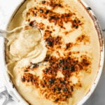 scalloped potatoes in a white casserole dish.