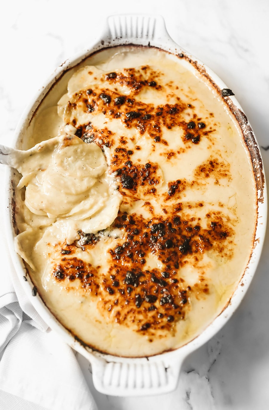 scalloped potatoes in a white casserole dish. 