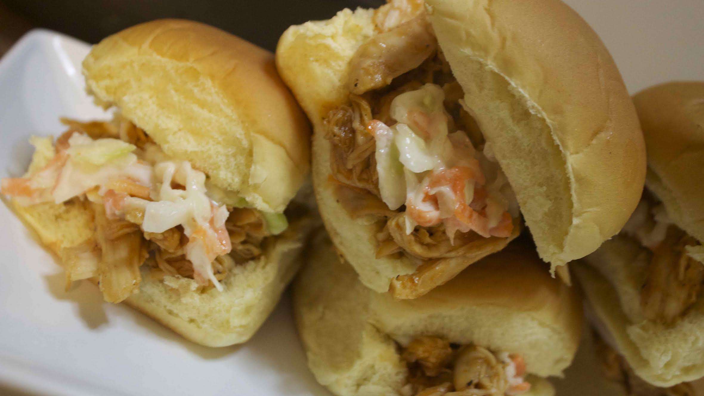 BBQ pulled chicken on soft dinner rolls topped with a sweet coleslaw 