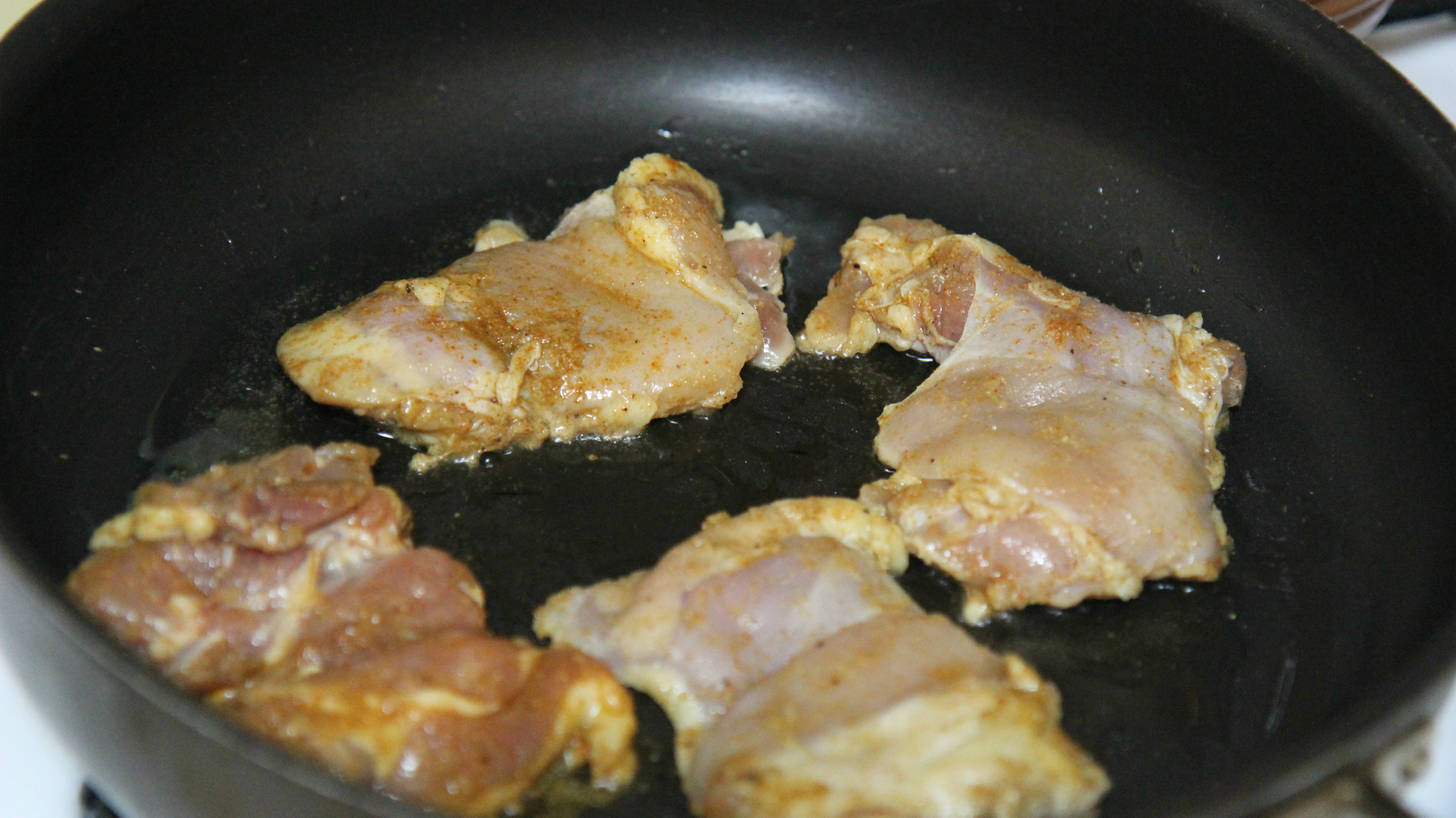 chicken thighs in a skillet.