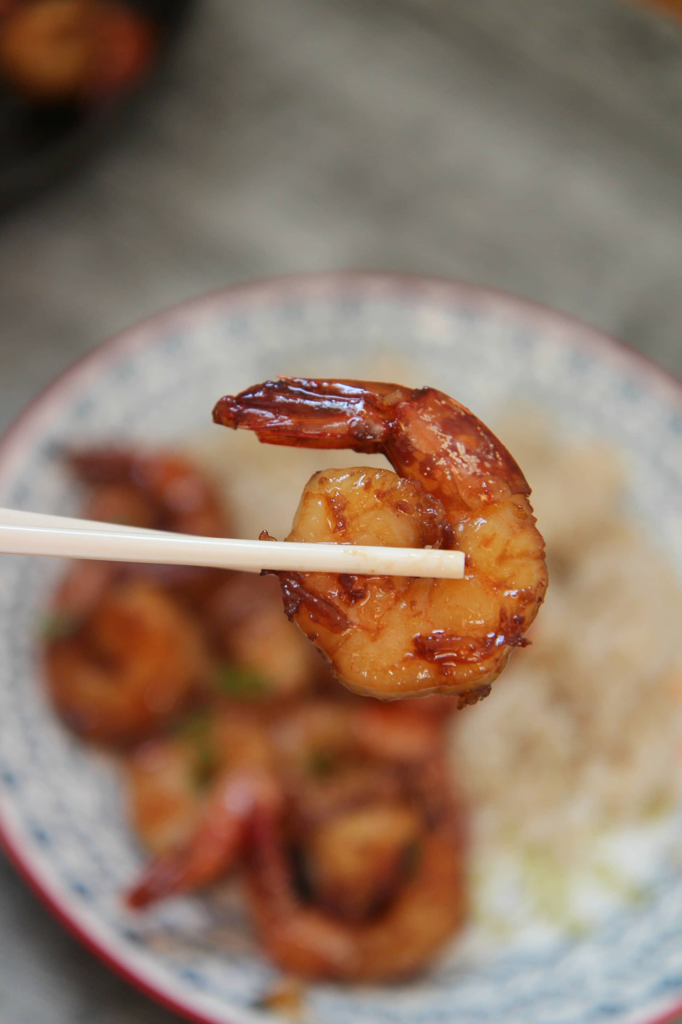 a chop stick holding a shrimp