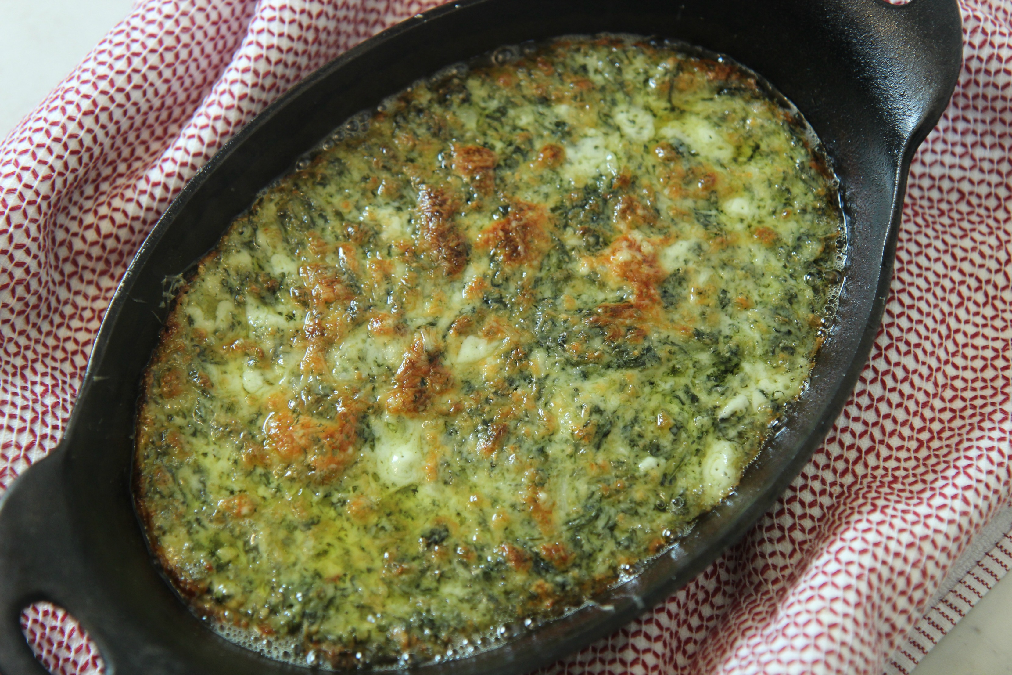 This spinach dip has a delicious cheesy baked crust that's perfect for dipping.