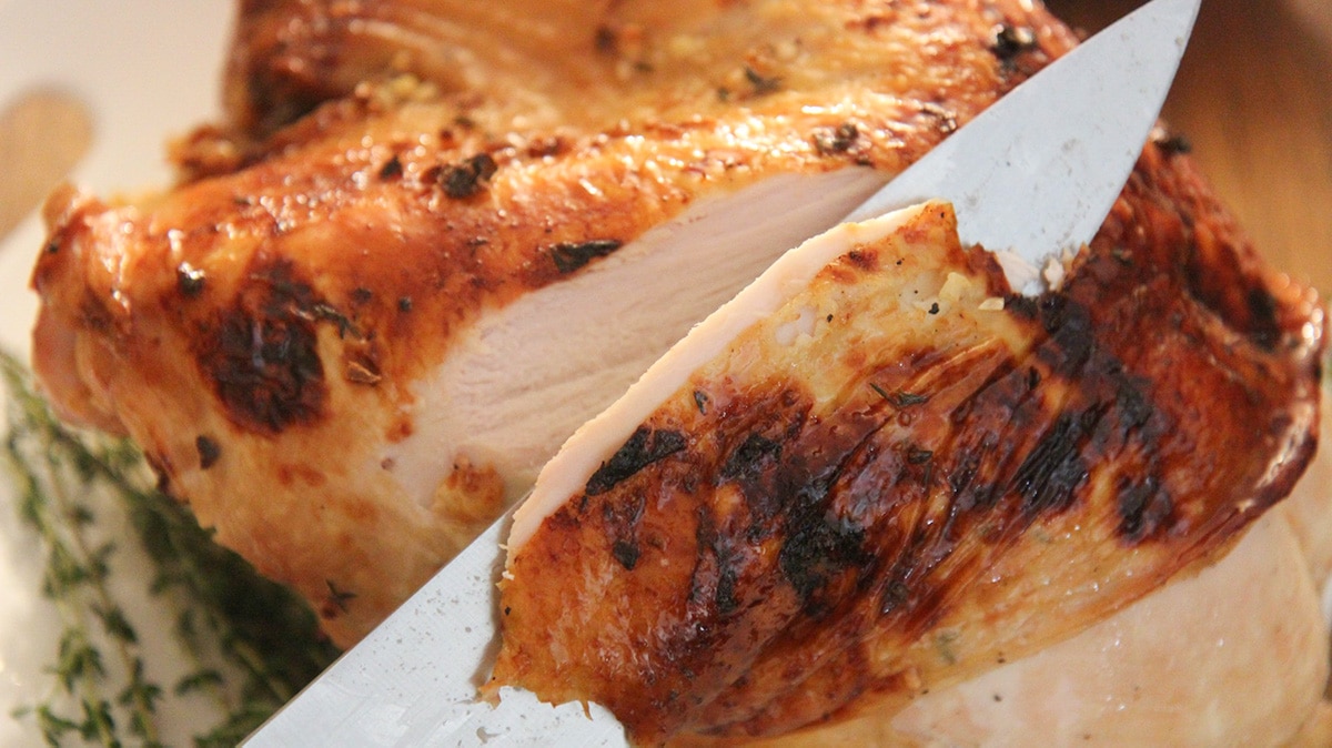 a knife slicing into a turkey breast. 