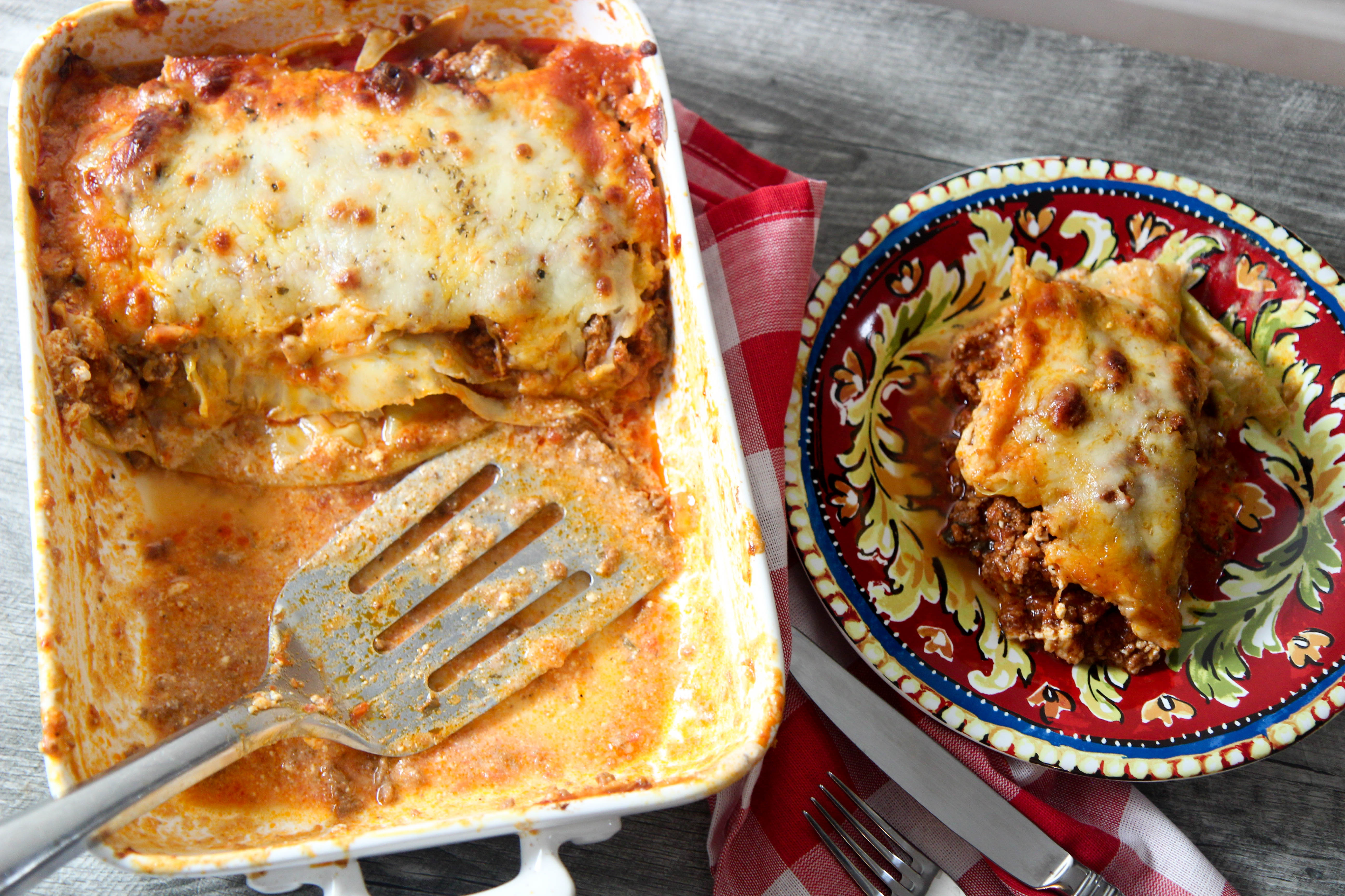 low carb lasagna in a white skillet with a small plate on the side