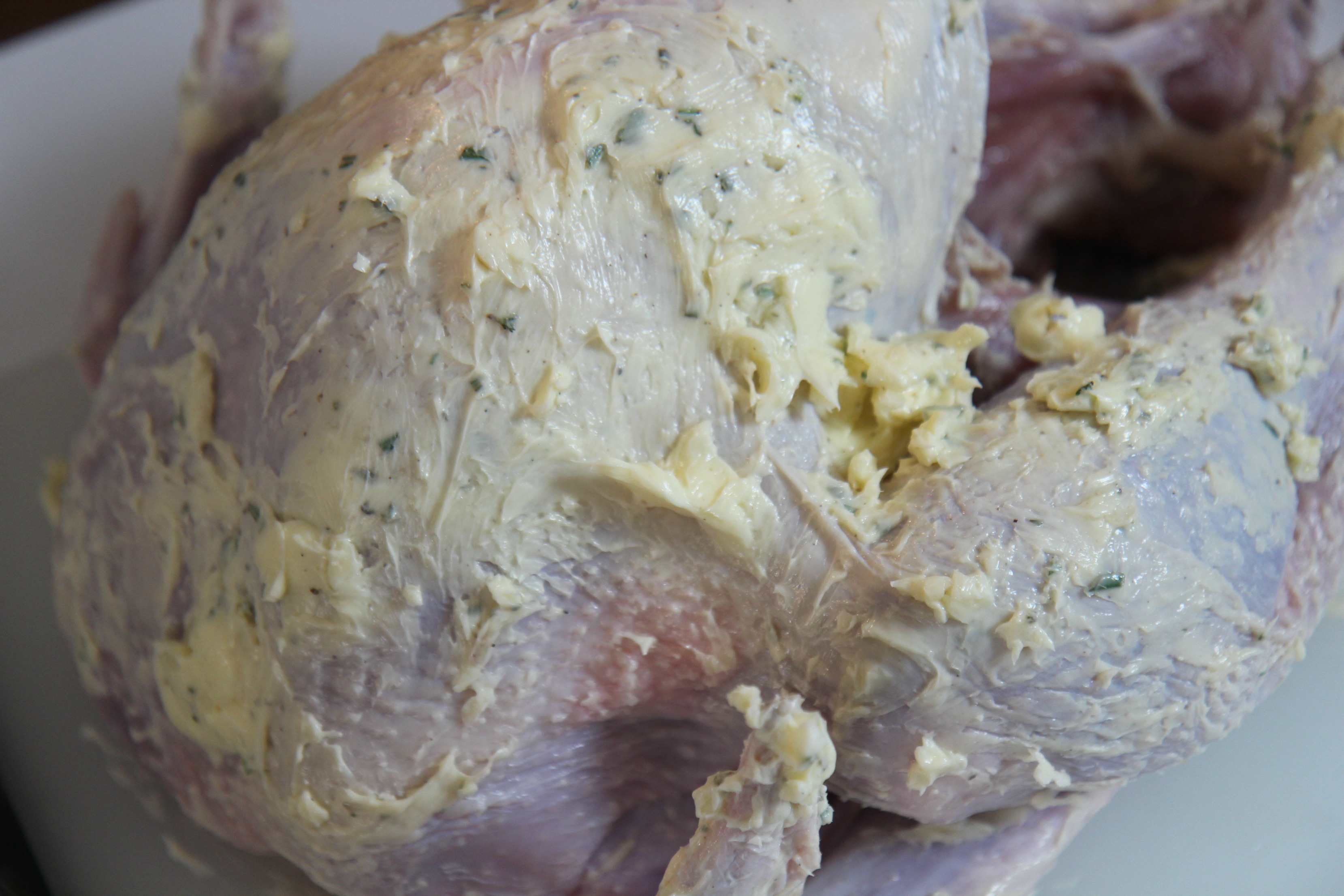 Rub the garlic and herb butter mixture over the raw turkey for a moist and flavorful roasted turkey.