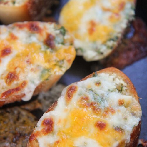 baked cheesy garlic bread slices up close.