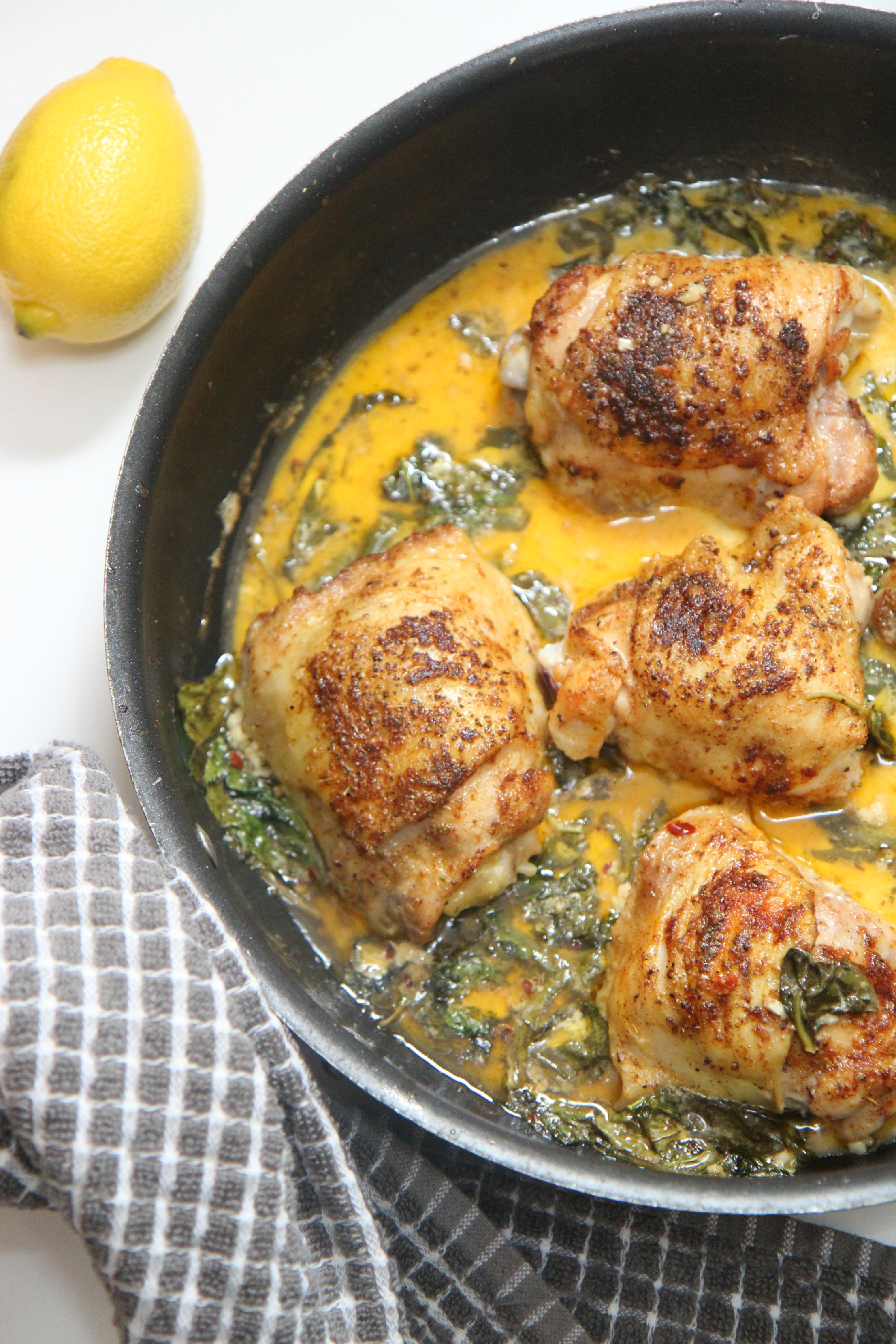 Lemon spinach chicken in a black skillet 