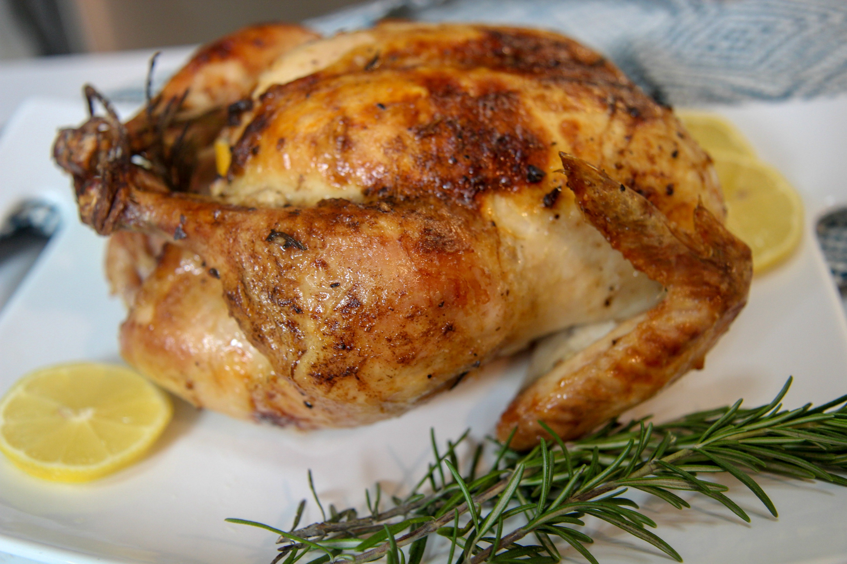 whole cooked chicken on a white platter