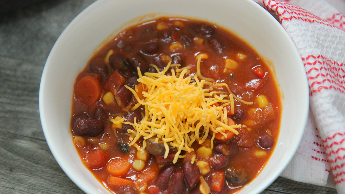 a small bowl of chili with shredded cheddar cheese on top