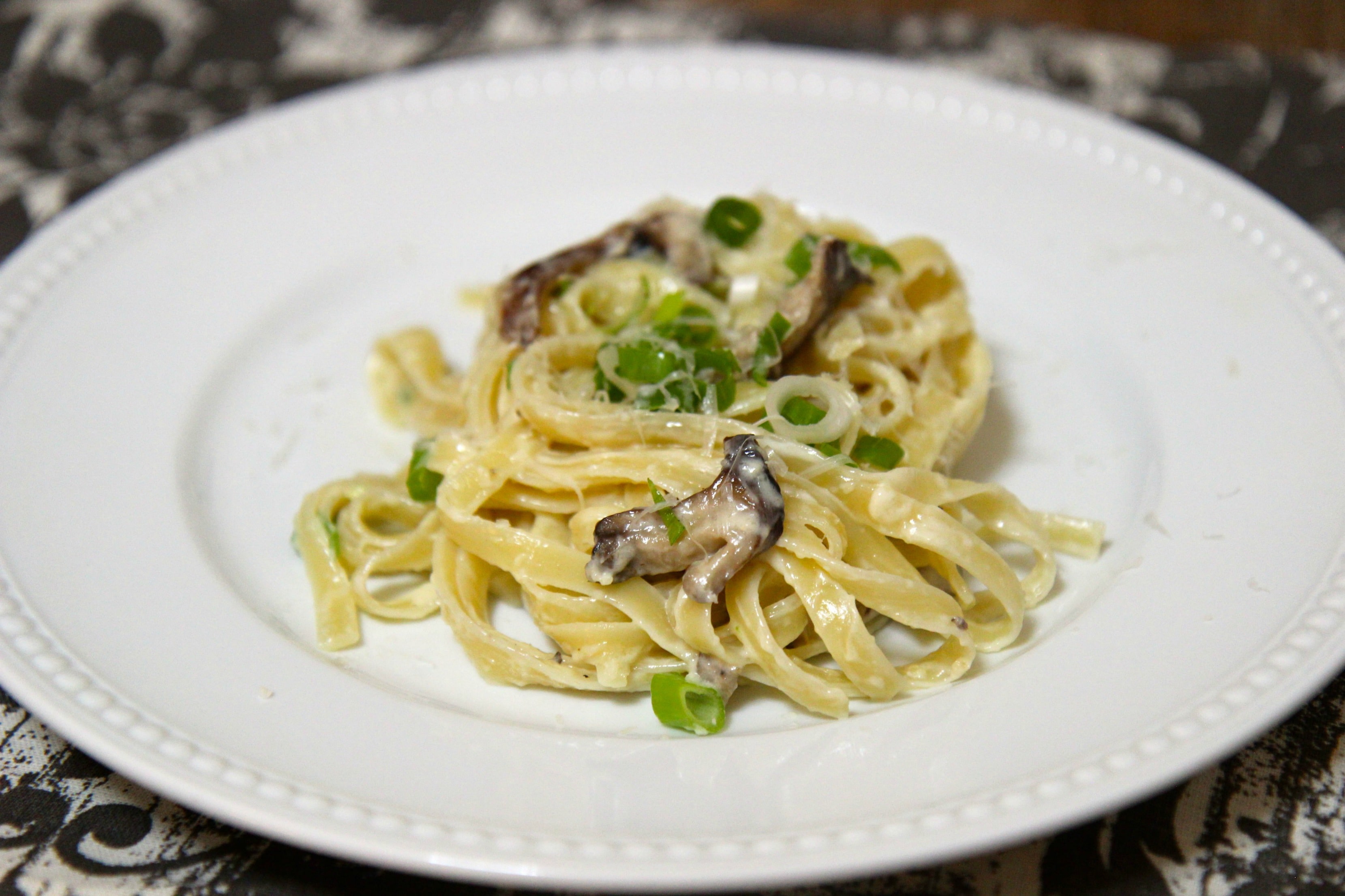 Al Dente pasta in a creamy alfredo sauce with mushrooms and green onions