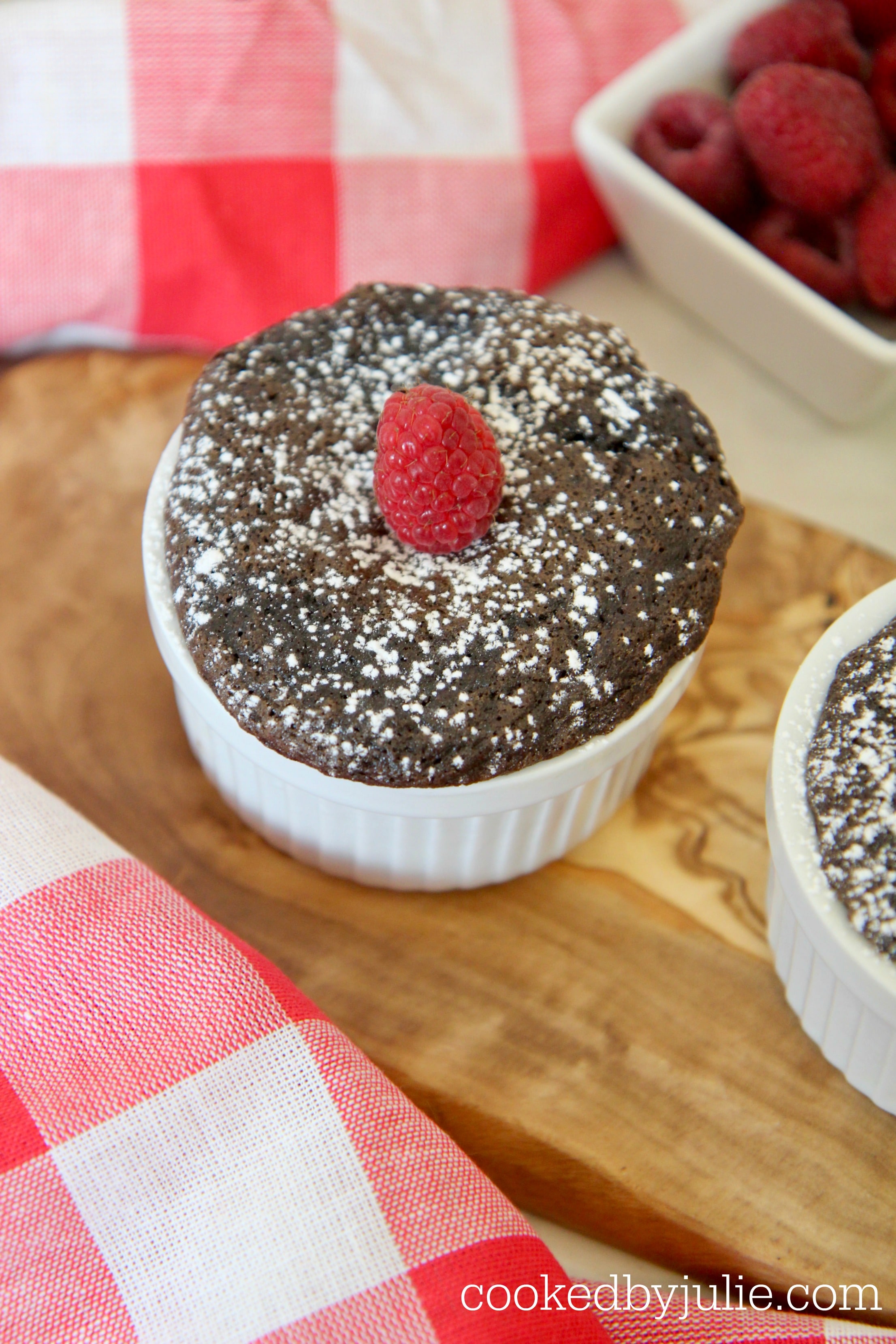 Mini Nutella cakes sprinkled with powdered sugar and topped with raspberries. 