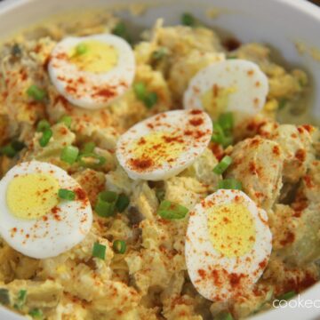potato and egg salad in a white bowl.