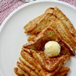 Easy French Toast served with softened butter, powdered sugar, and warm maple syrup.