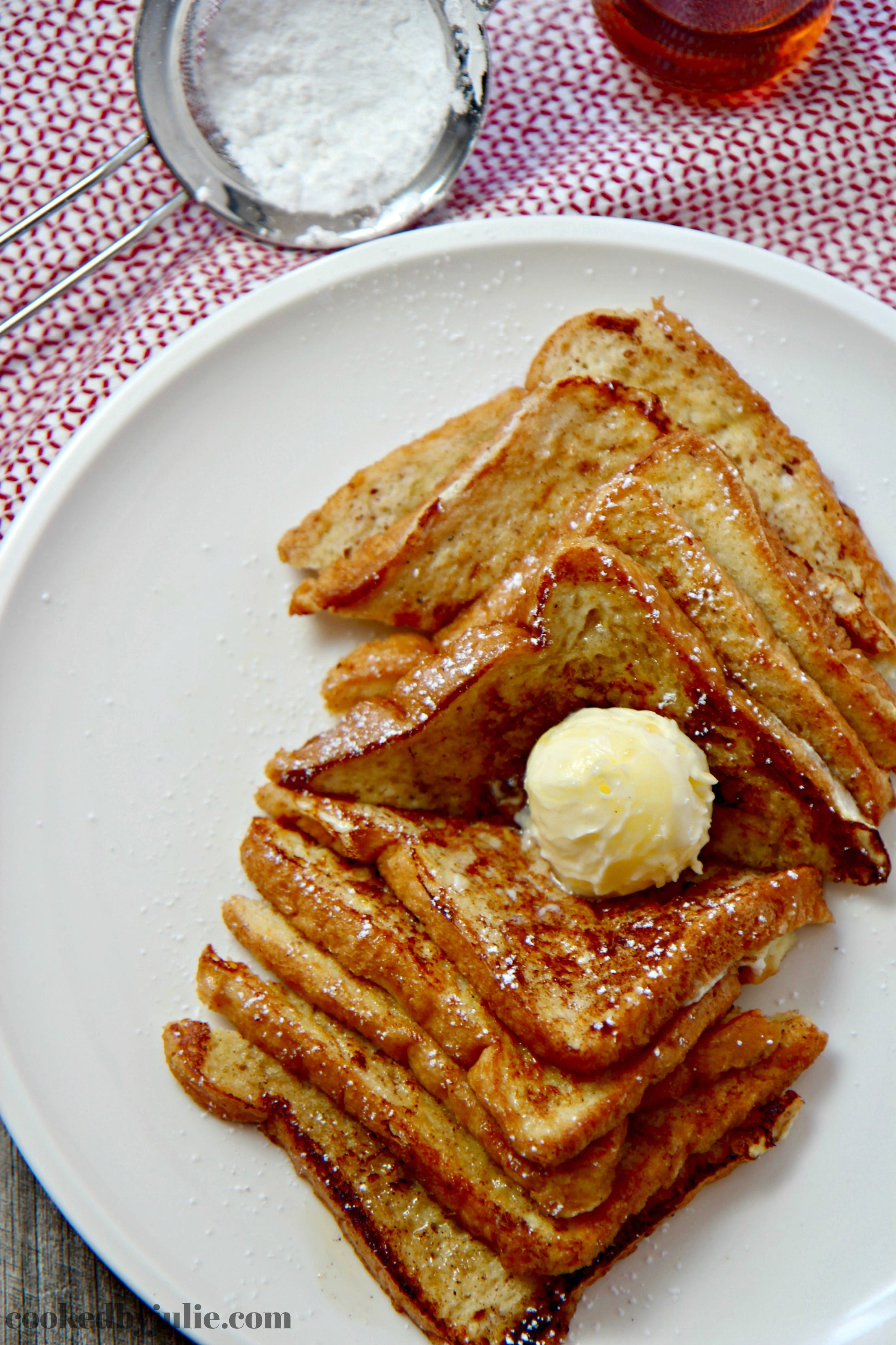 Easy French Toast served with softened butter, powdered sugar, and warm maple syrup.