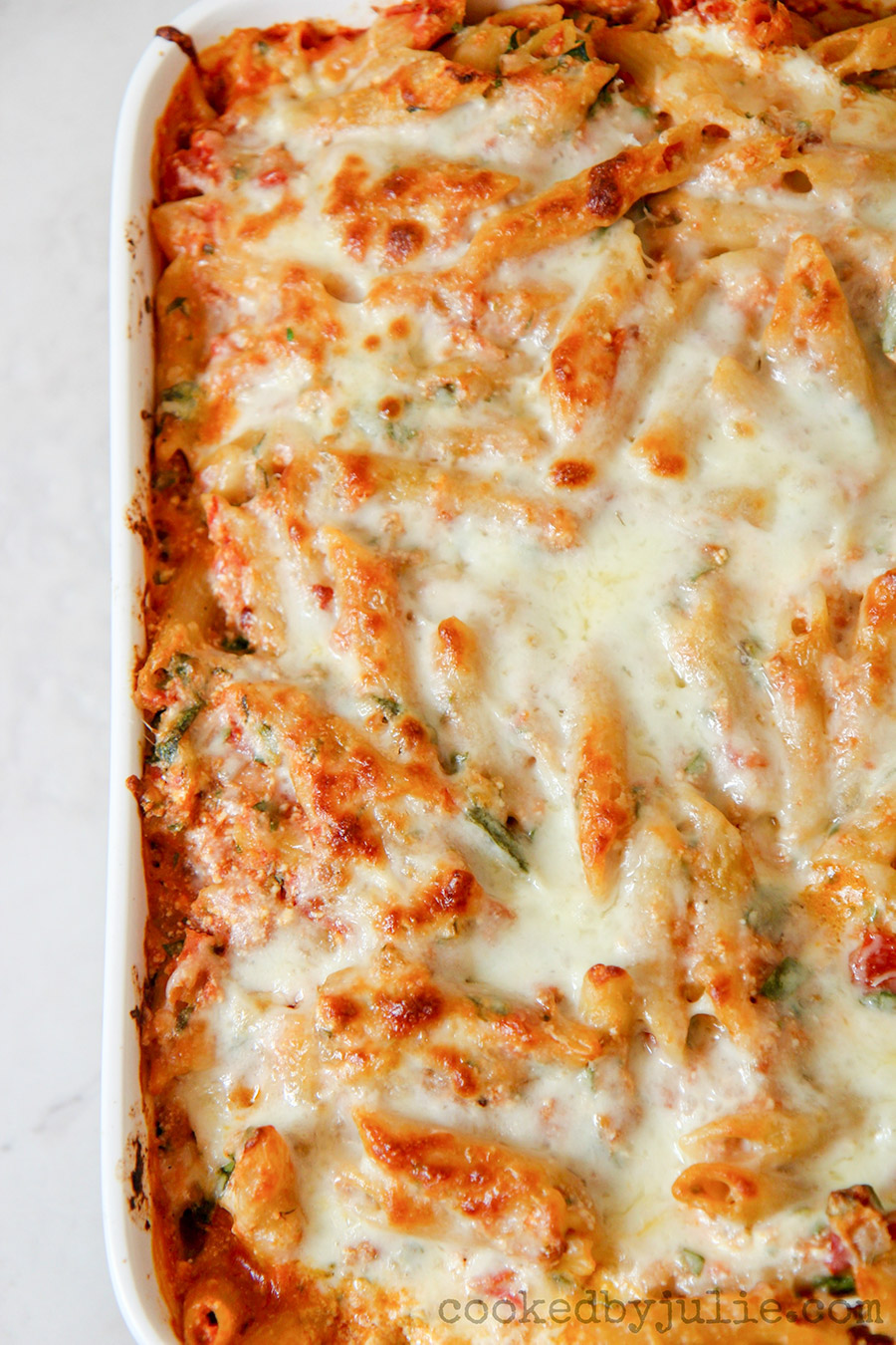 penne pasta with spinach and cheese in a casserole dish 