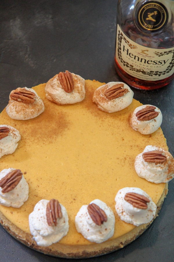 pumpkin cognac cheesecake with whipped cream and pecans