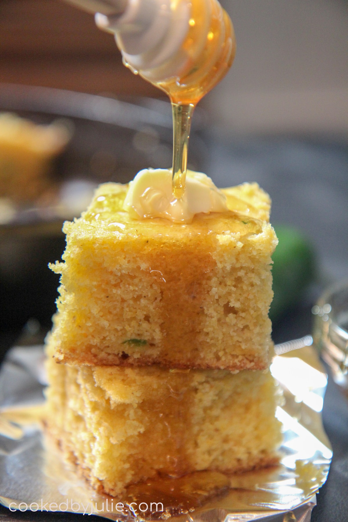 a honey comb pouring maple syrup over two slices of cornbread. 