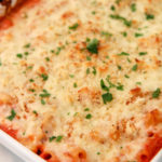 Olive garden baked ziti in a white casserole dish with fresh parsley on top