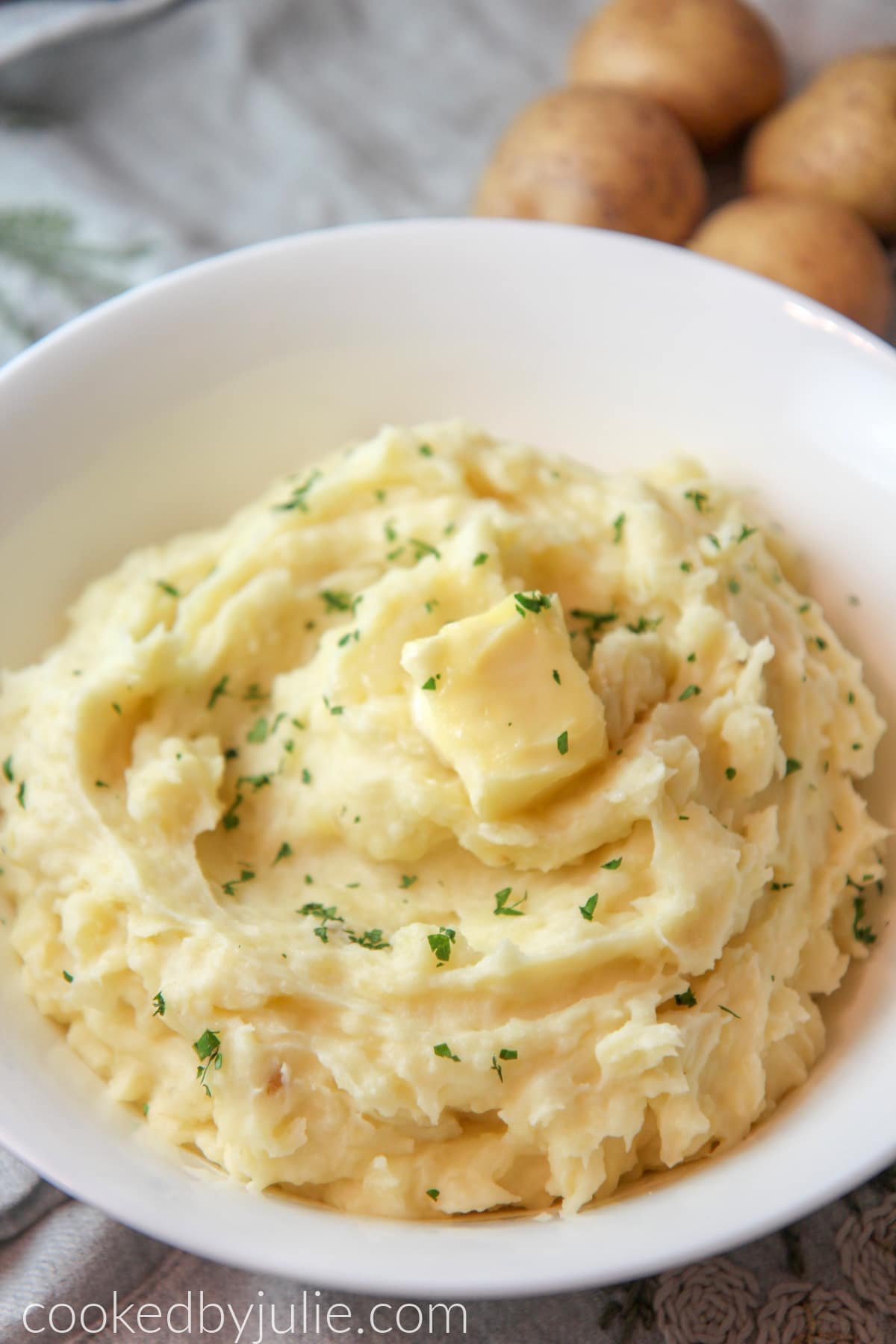 mashed potatoes in a bowl with butter and fresh parsley 