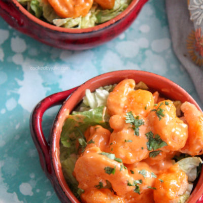 fried shrimp coated in mayo based dressing with fresh parsley on top